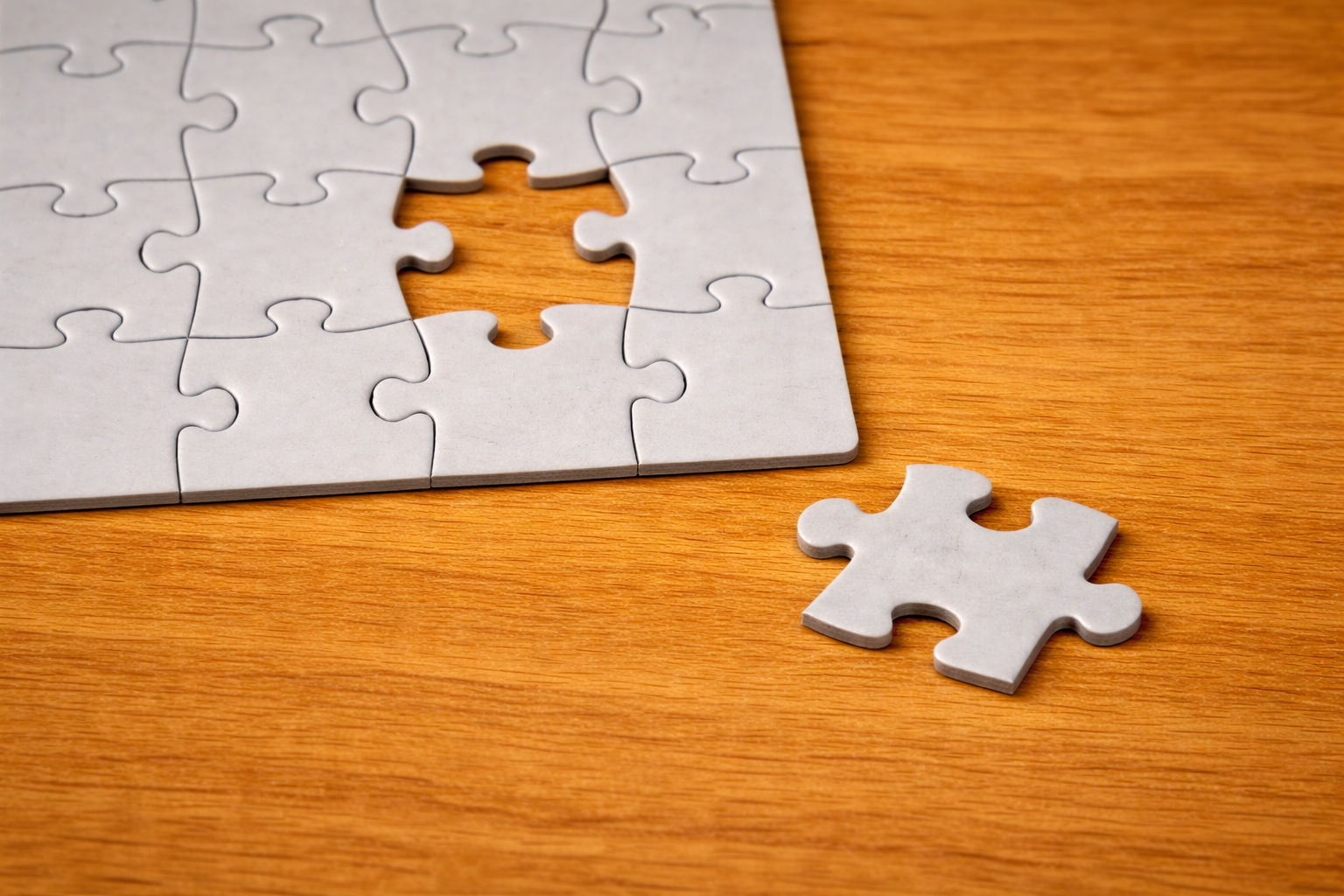Piesă de puzzle lipsă lângă un ansamblu incomplet, simbol al completării unei poziții în organigrama companiei